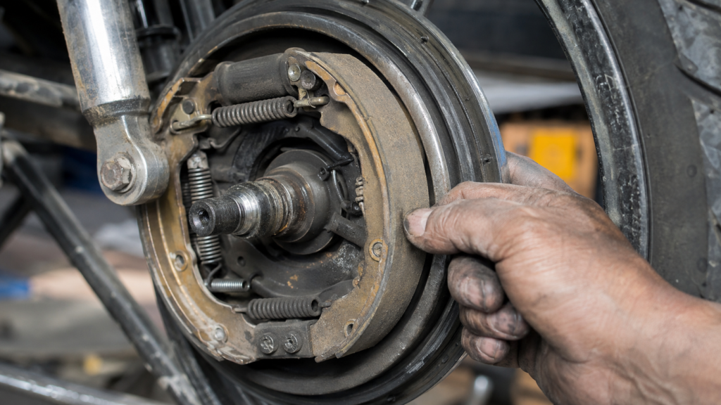 Mechanic inspecting a motorcycle rear drum brake